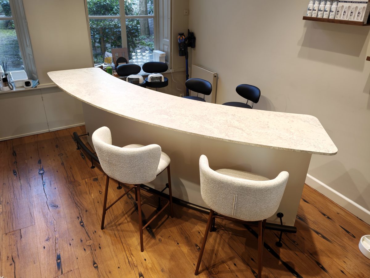 Maatwerk restauranttafel met licht blad en barkrukken bij het raam